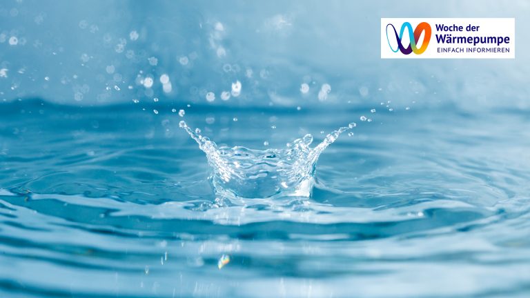 Ein Wassertropfen trifft auf die Wasseroberfläche und erzeugt eine spritzende Krone – symbolisch für die Nutzung von Wasser als nachhaltige Wärmequelle.